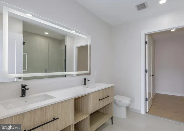 a bathroom with a sink a toilet and a mirror