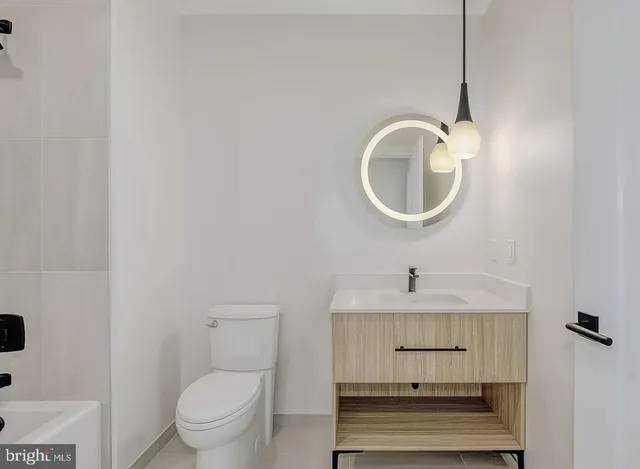a bathroom with a toilet a sink and mirror