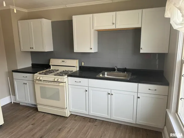 a kitchen with white cabinets and white appliances
