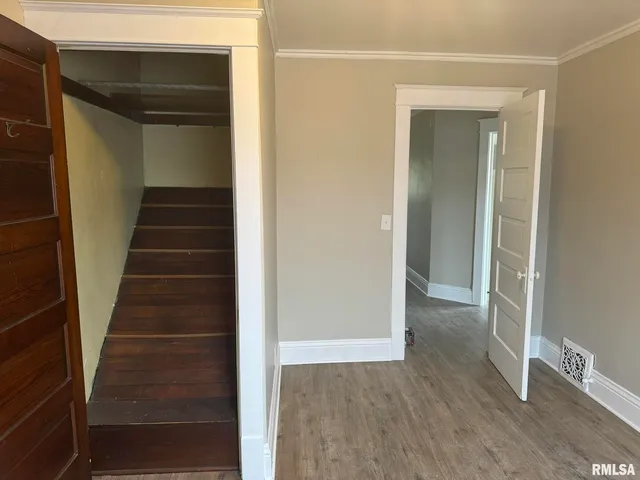 a view of a hallway with wooden floor and entryway