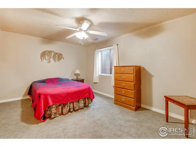 a spacious bedroom with a bed and a chandelier
