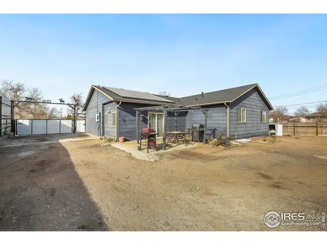 a backyard of a house with barbeque oven table and chairs