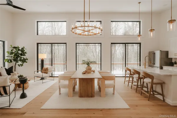 a view of a dining room with furniture a chandelier and wooden floor