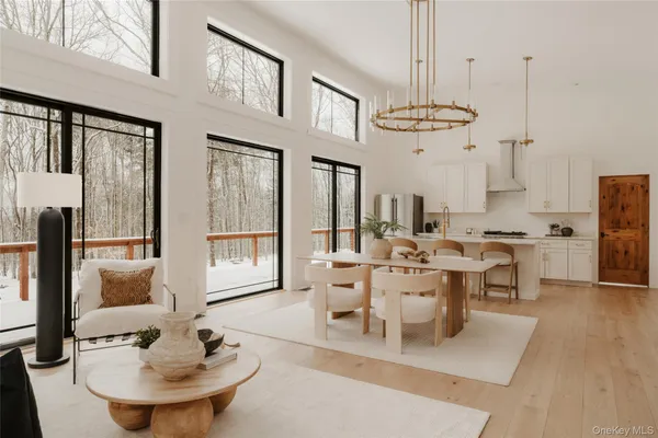 a living room with furniture a dining table and a chandelier