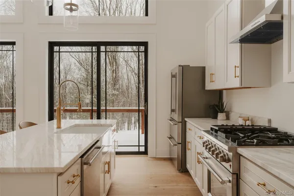 a kitchen with granite countertop a sink stove and refrigerator