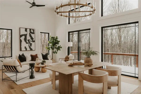 a living room with furniture a chandelier and a dining table