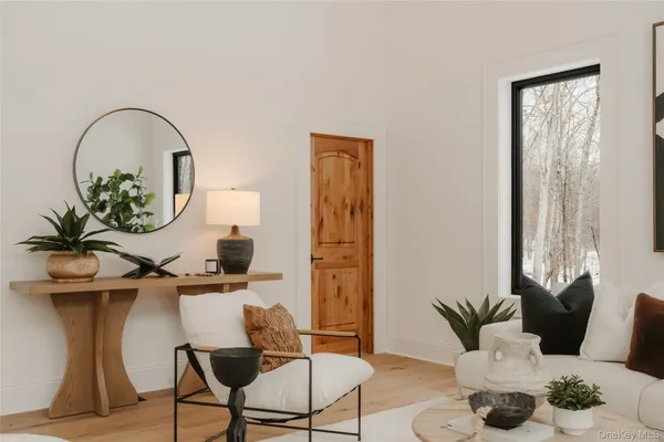 a living room with furniture a potted plant and a window