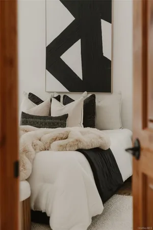 a bedroom with a bed and painting on the wall