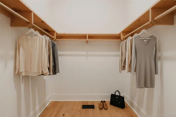 a view of walk in closet with clothes and shoes