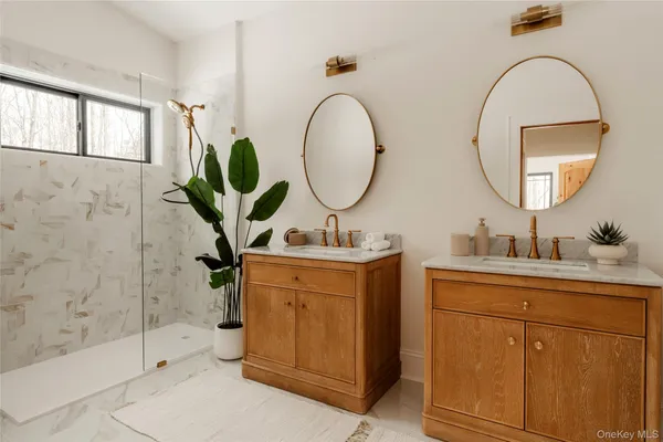 a bathroom with a double vanity sink mirror and shower