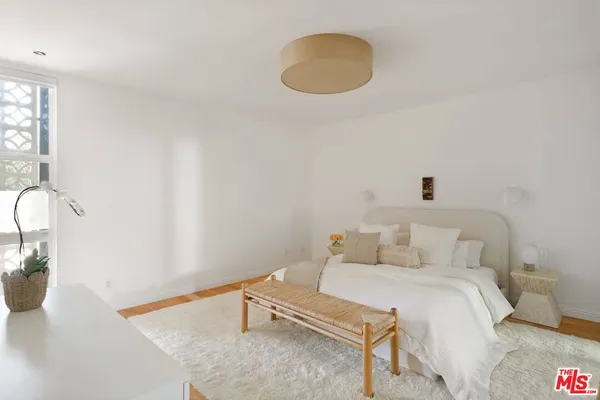 a spacious bedroom with a bed and a chandelier