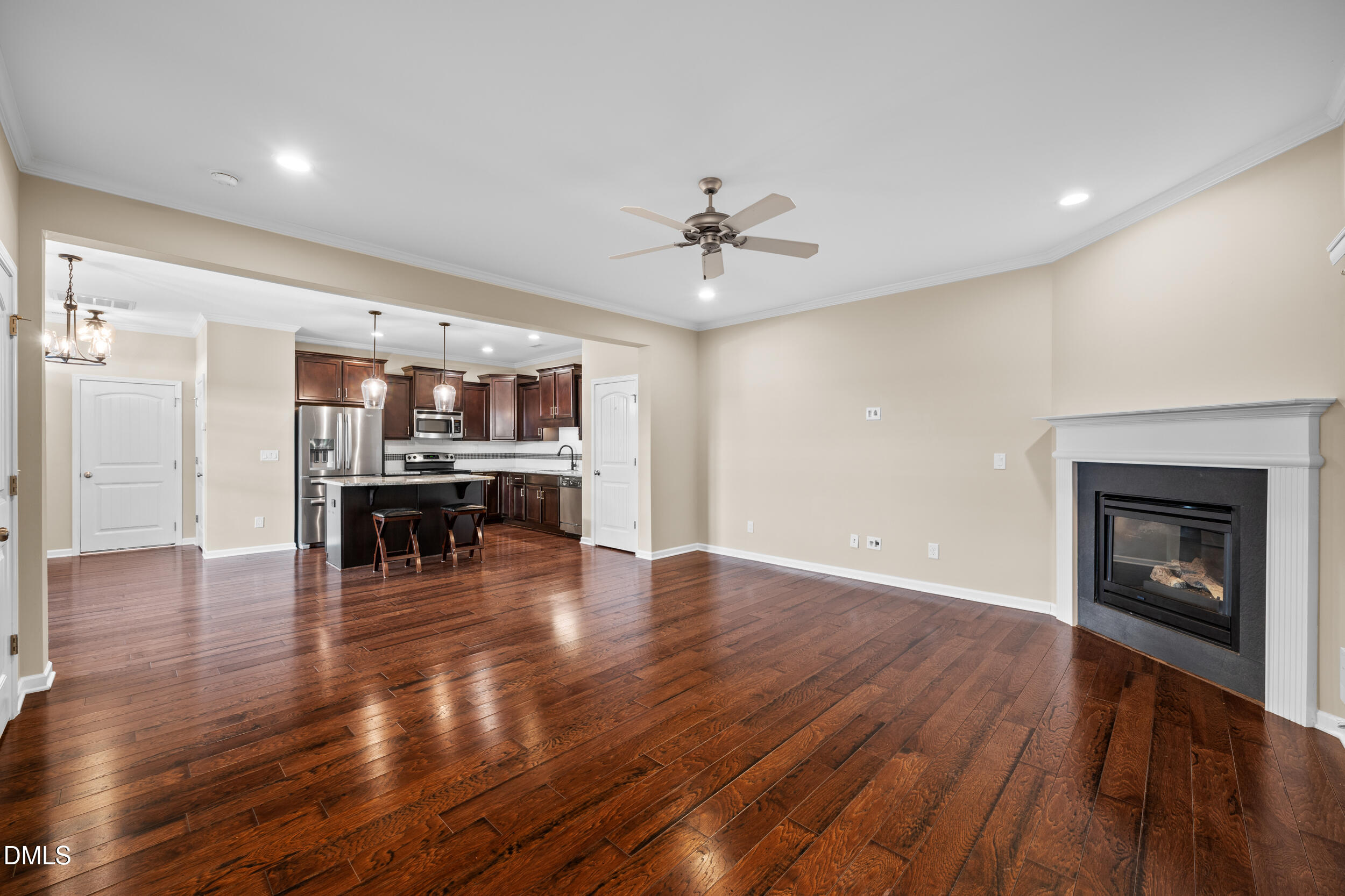 1217 Silver Beach Way Raleigh, NC 27606 - Photo 13 of 32 a view of an empty room and kitchen with fireplace wooden floor and fire place