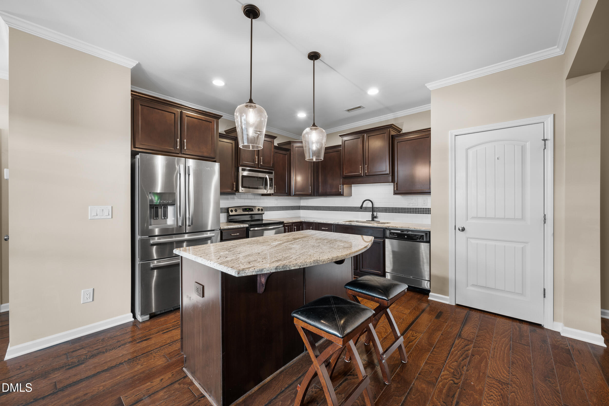 1217 Silver Beach Way Raleigh, NC 27606 - Photo 6 of 32 a kitchen with stainless steel appliances kitchen island a hardwood floor and a sink