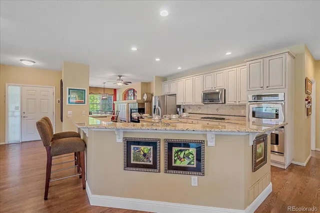 a kitchen with kitchen island granite countertop a stove and a refrigerator