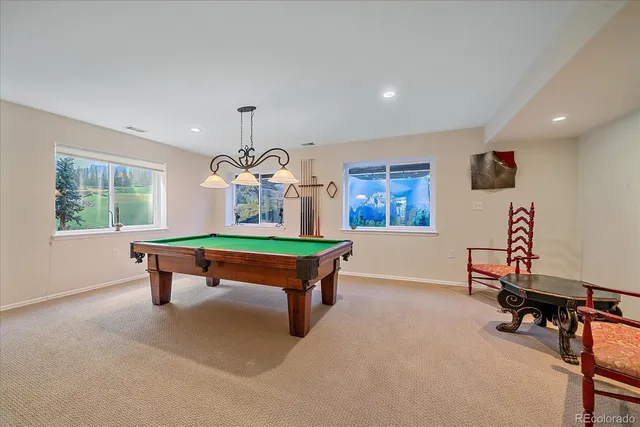 a room with pool table and windows