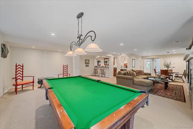 a living room with furniture and a pool table