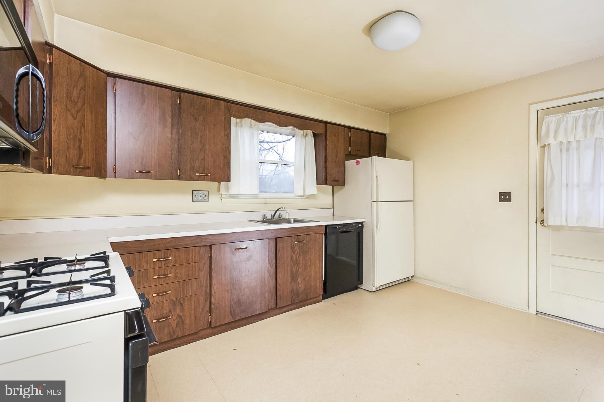 6738 Fordcrest Road Baltimore, MD 21237 - Photo 9 of 28 a kitchen with a sink a stove a refrigerator and cabinets