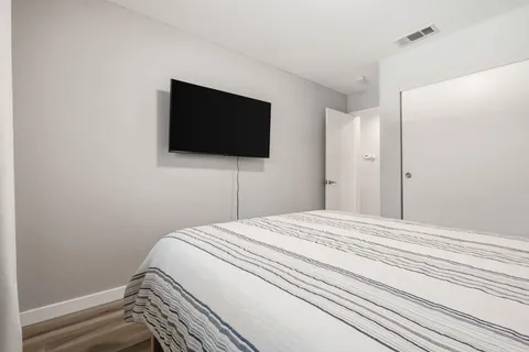 a bedroom with a bed and a flat screen tv