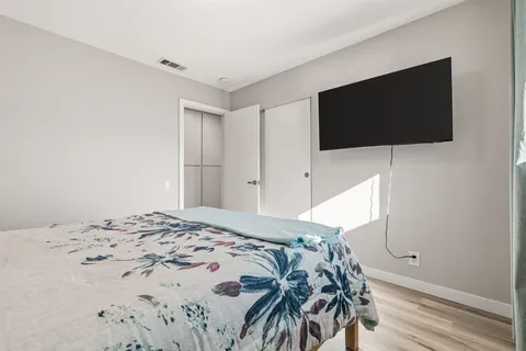 a bedroom with a bed and a flat screen tv