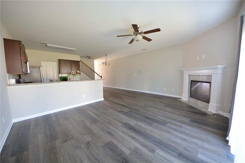4722 Beacon Ridge Lane Flowery Branch, GA 30542 - Photo 11 of 24 a view of a kitchen and empty room with wooden floor