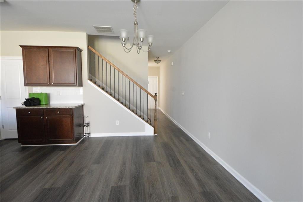 4722 Beacon Ridge Lane Flowery Branch, GA 30542 - Photo 6 of 24 a view of a hallway with wooden floor and staircase