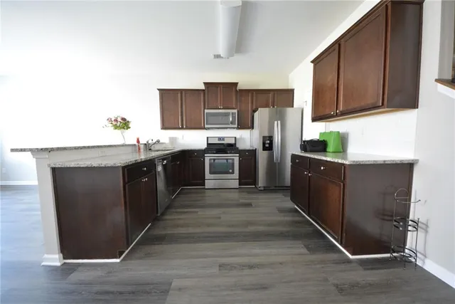 a kitchen with granite countertop stainless steel appliances and wooden cabinets