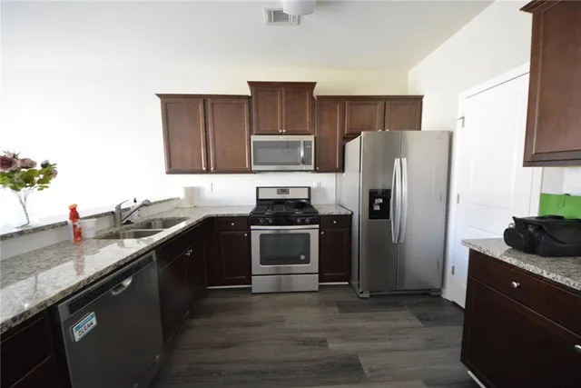 an empty room with wooden floor fireplace and windows