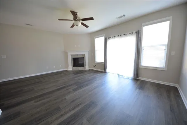 a view of a kitchen and empty room with wooden floor