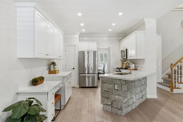 a kitchen with refrigerator a stove a sink dishwasher and wooden cabinets with wooden floor