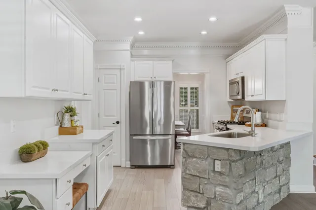 a kitchen with stainless steel appliances granite countertop a refrigerator a stove a sink dishwasher and a microwave with wooden floor