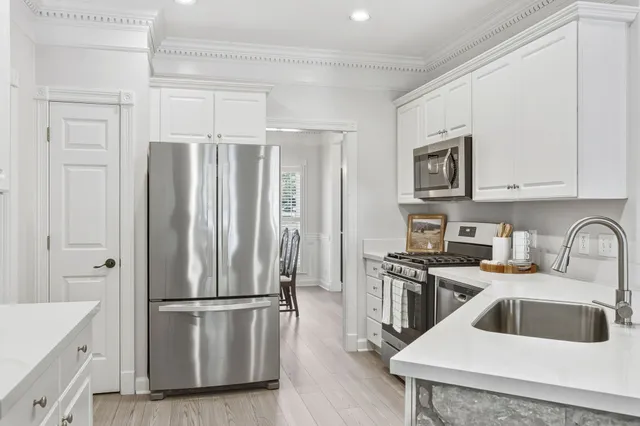 a kitchen with a refrigerator sink and cabinets