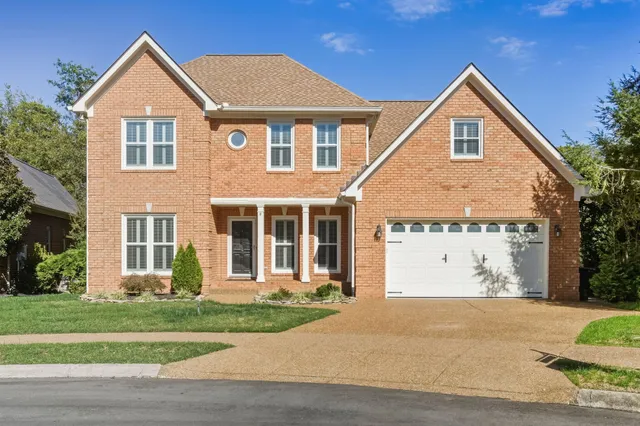 a front view of a house with a garden and plants