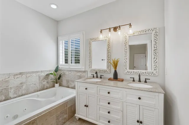 a bathroom with a tub sink and mirror