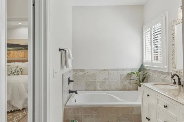 a bathroom with a granite countertop bathtub sink and mirror