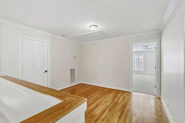 a view of a room with wooden floor and white walls