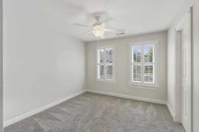 an empty room with a window and a fan