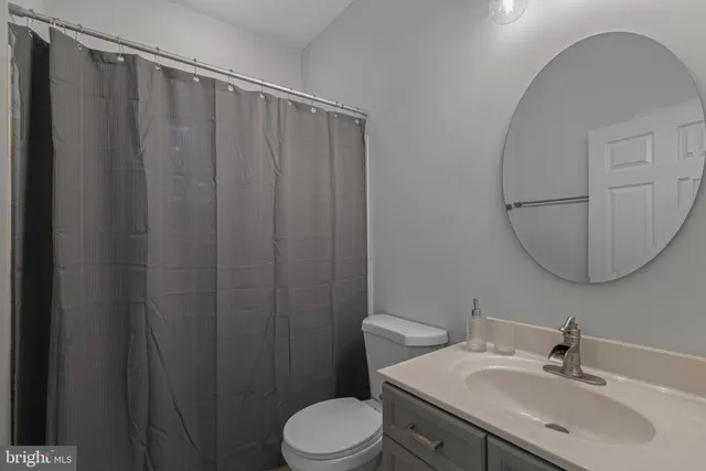 a bathroom with a sink vanity mirror and toilet