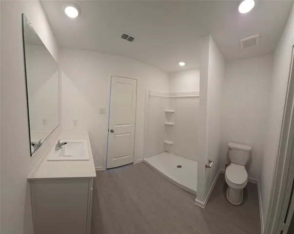 a bathroom with a sink a toilet and shower