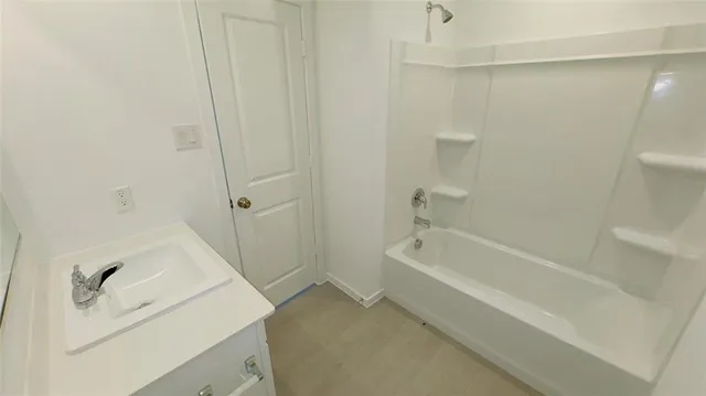 a bathroom with a tub sink and vanity