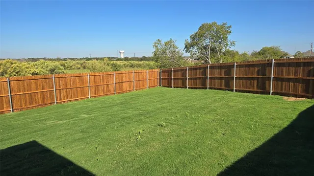 a view of a yard with wooden fence