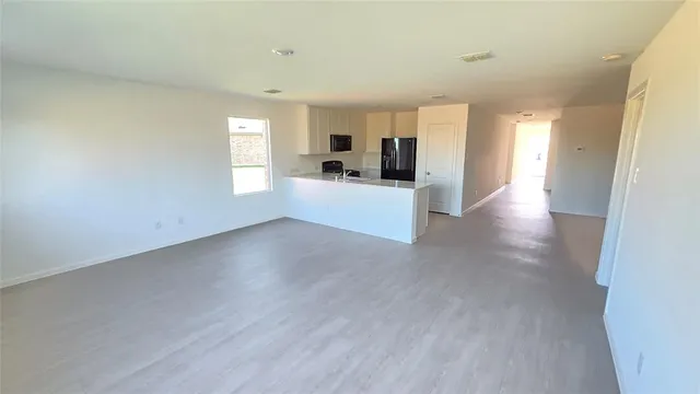 a view of a living room hardwood floor and a window