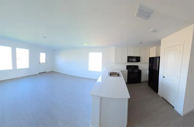 a view of a kitchen with a sink refrigerator kitchen island and windows