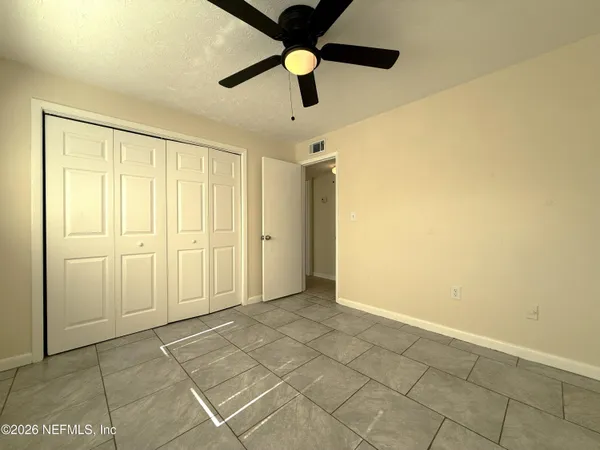 a view of an empty room with a ceiling fan