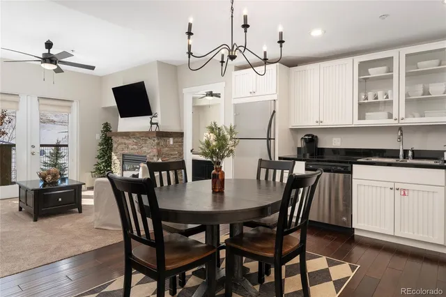 a kitchen with a dining table chairs and white cabinets