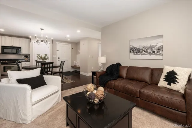 a living room with furniture a rug and kitchen view