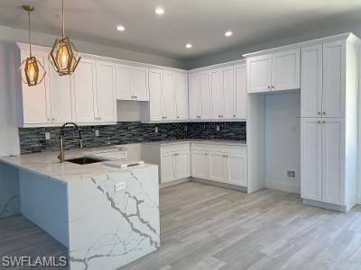3651 29th Avenue Southwest Naples, FL 34117 - Photo 3 of 8 a kitchen with granite countertop white cabinets and stainless steel appliances