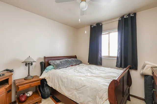 a bedroom with a bed and dresser with mirror