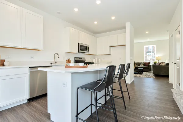 a kitchen with a dining table chairs and cabinets