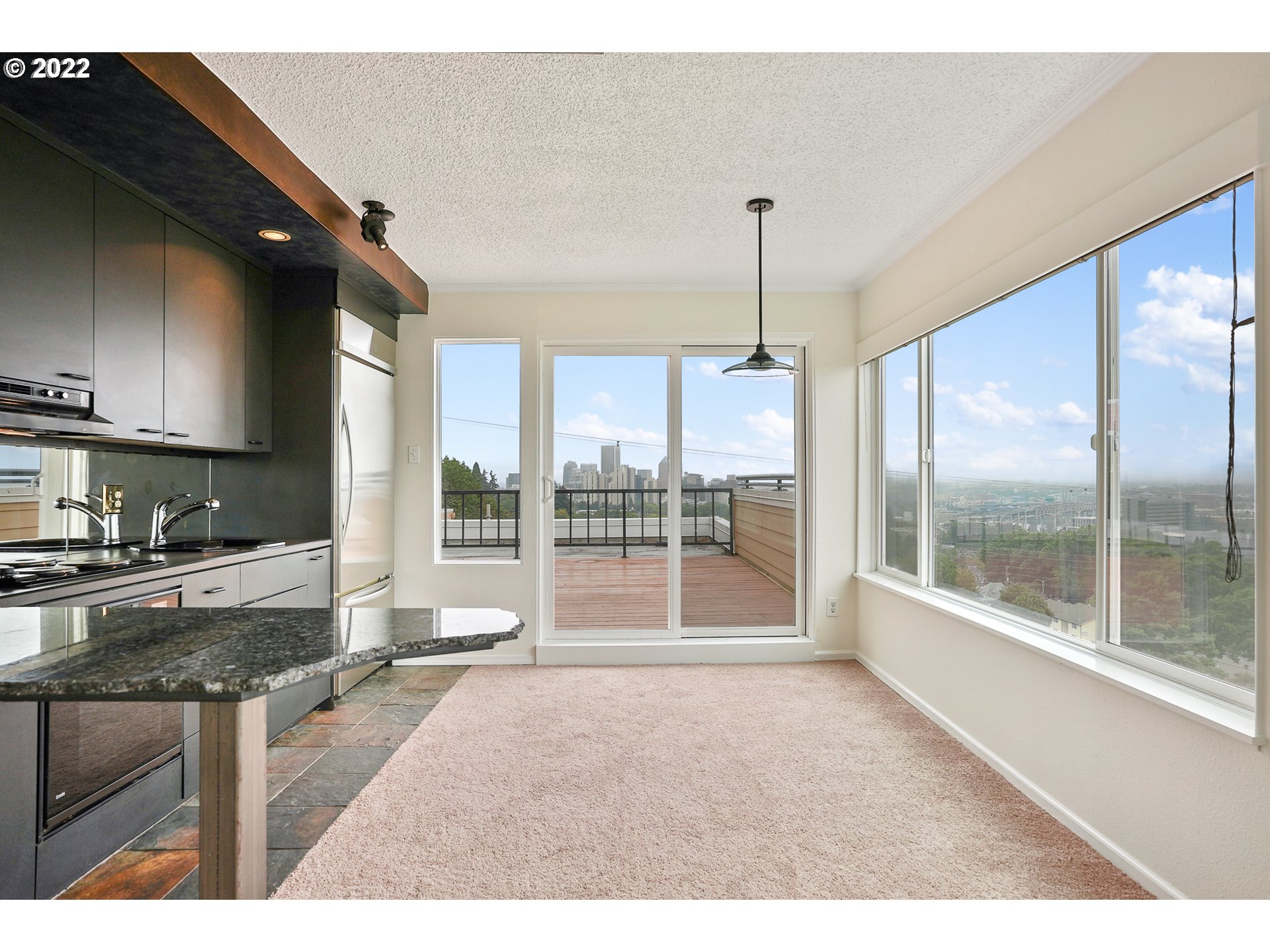 3701 Southwest Condor Avenue, Unit T3 Portland, OR 97239 - Photo 5 of 23 a open kitchen with granite countertop a sink and a refrigerator