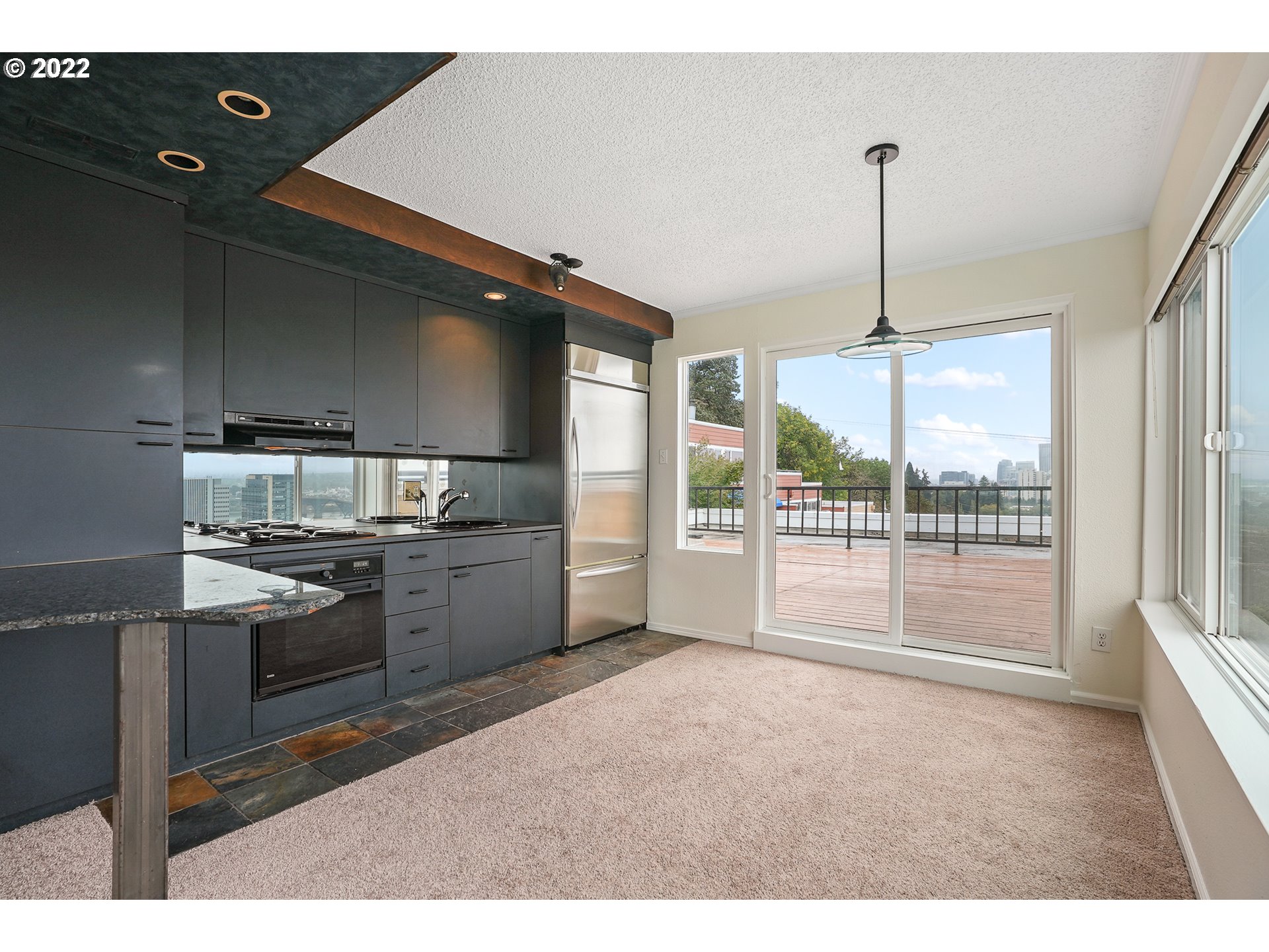 3701 Southwest Condor Avenue, Unit T3 Portland, OR 97239 - Photo 6 of 23 a kitchen with kitchen island a counter top a stove and a shower